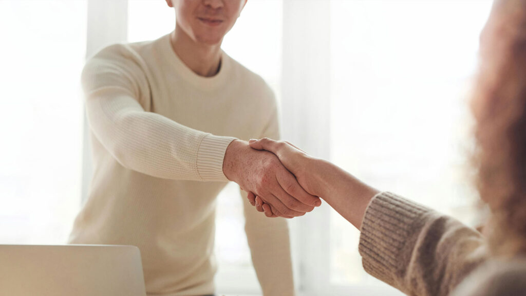 a man and woman shaking hands delaware title search and encumbrance