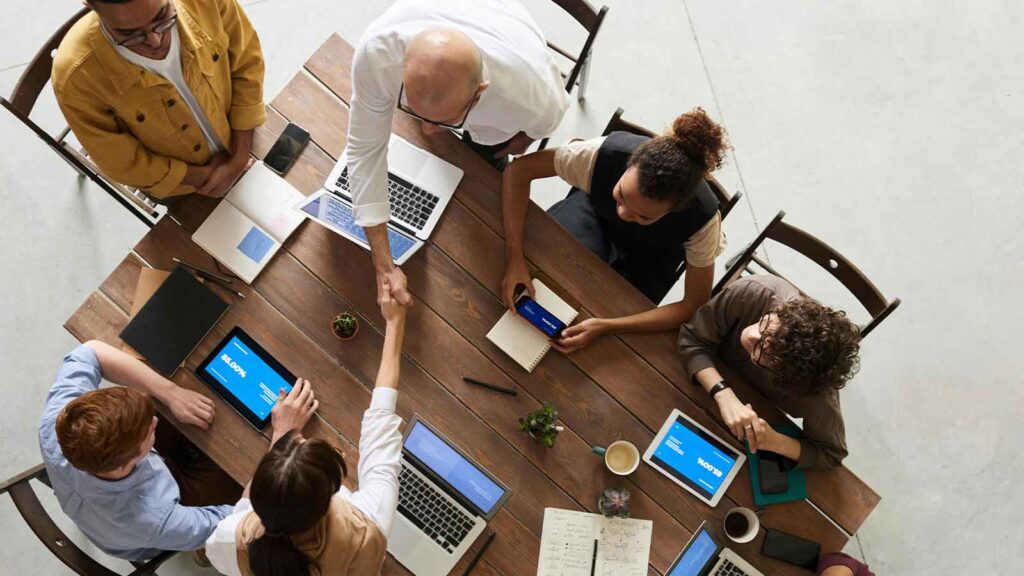 a group of people around a table with laptops New Hampshire Title Search
