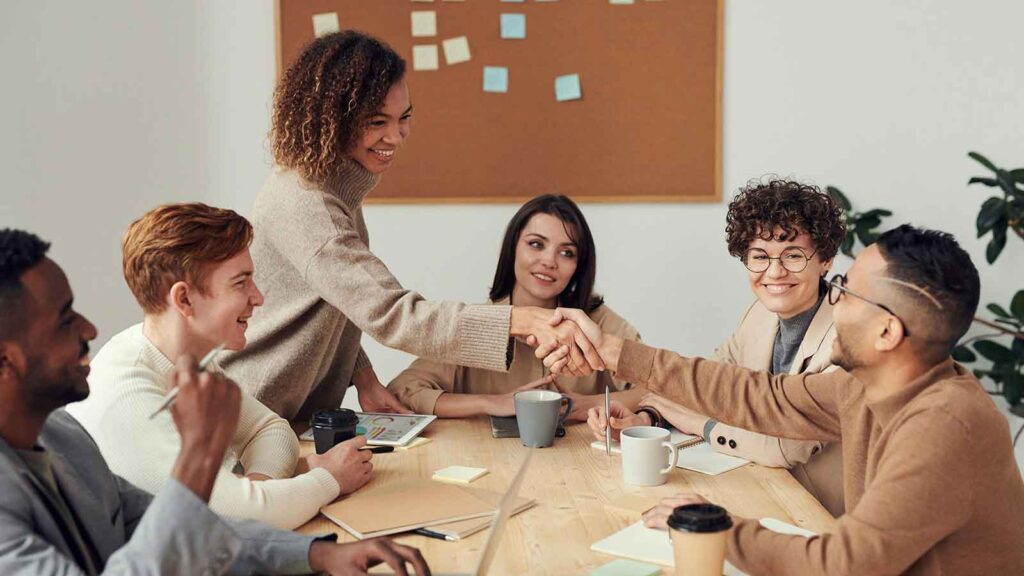 a group of people around a table shaking hands talking about preliminary title report title report difference between title and Title Search in South Dakotaabstractor cloud on title lien release