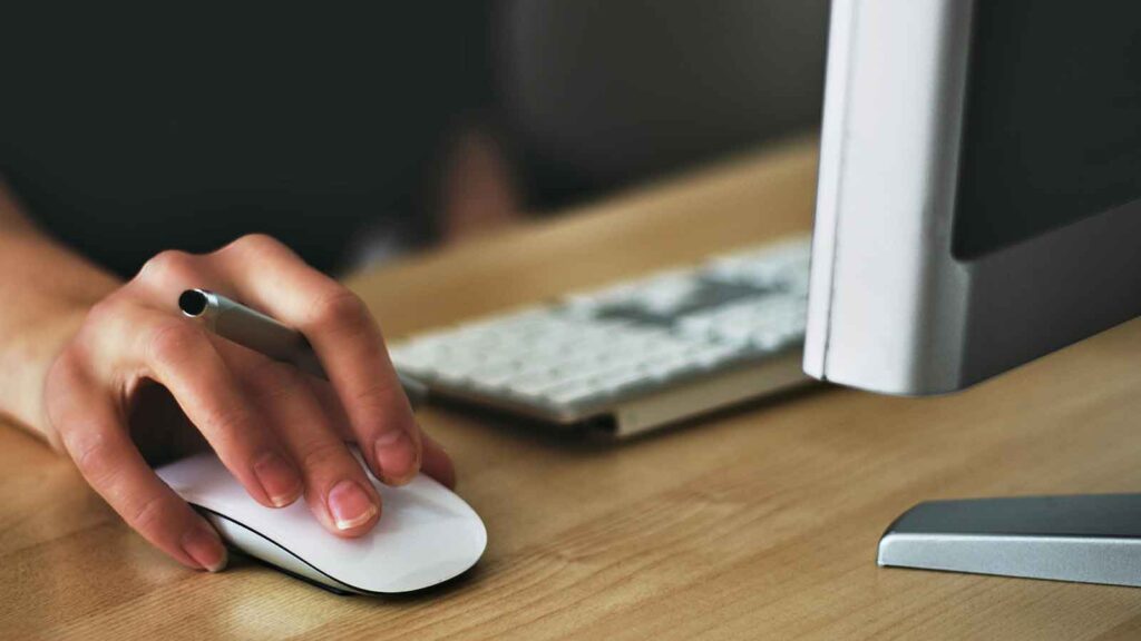 a hand on a mouse searching preliminary title report Title Search in South Dakota