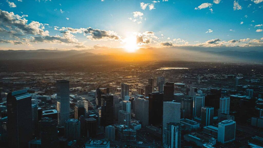 a city with many tall buildings and a sunset title search in colorado