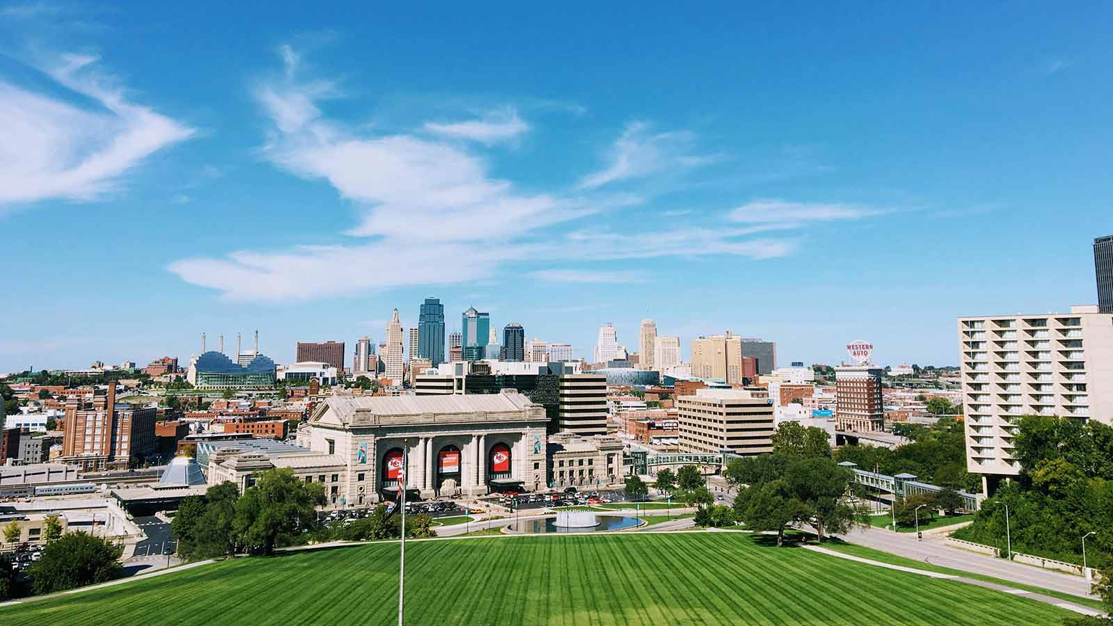 a large green lawn with a large building and a city in the background Kansas title search