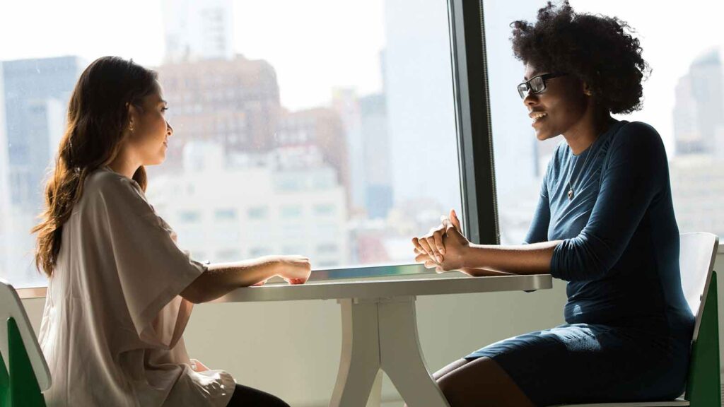 a woman and a woman sitting at a table Indiana Title Search
