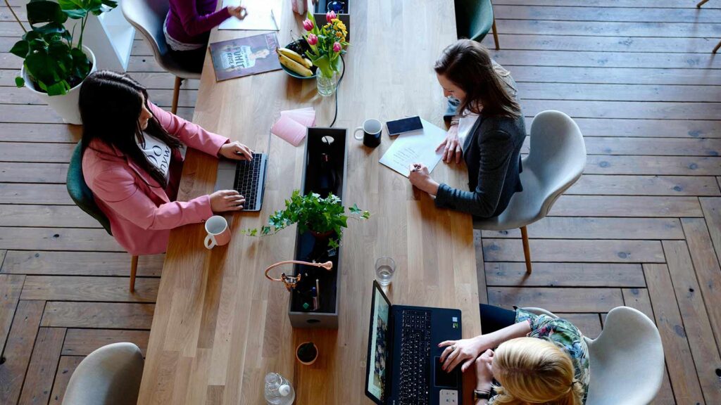 a group of people sitting around a table with laptops nebraska title search