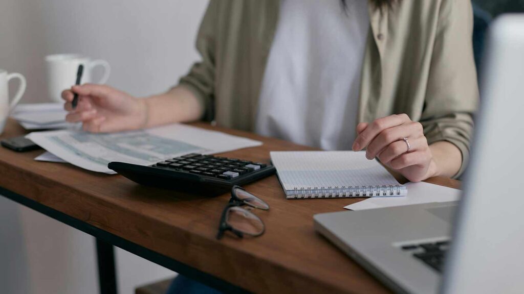 a person holding a calculator and a notebook New Hampshire Title Search