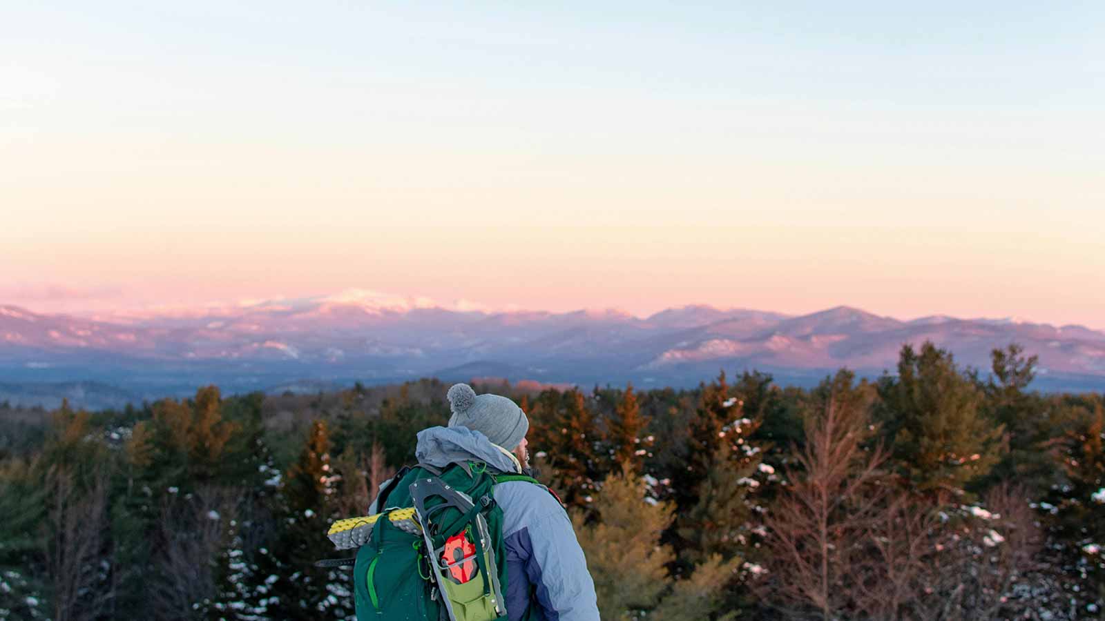 a man with a backpack looking at a mountain range New Hampshire Title Search