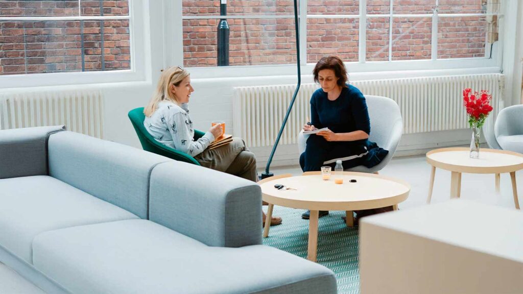 a woman sitting in a chair and holding a bookv Rising Interest Rates
