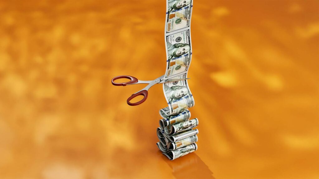 scissors cutting dollar bills Rising Interest Rates