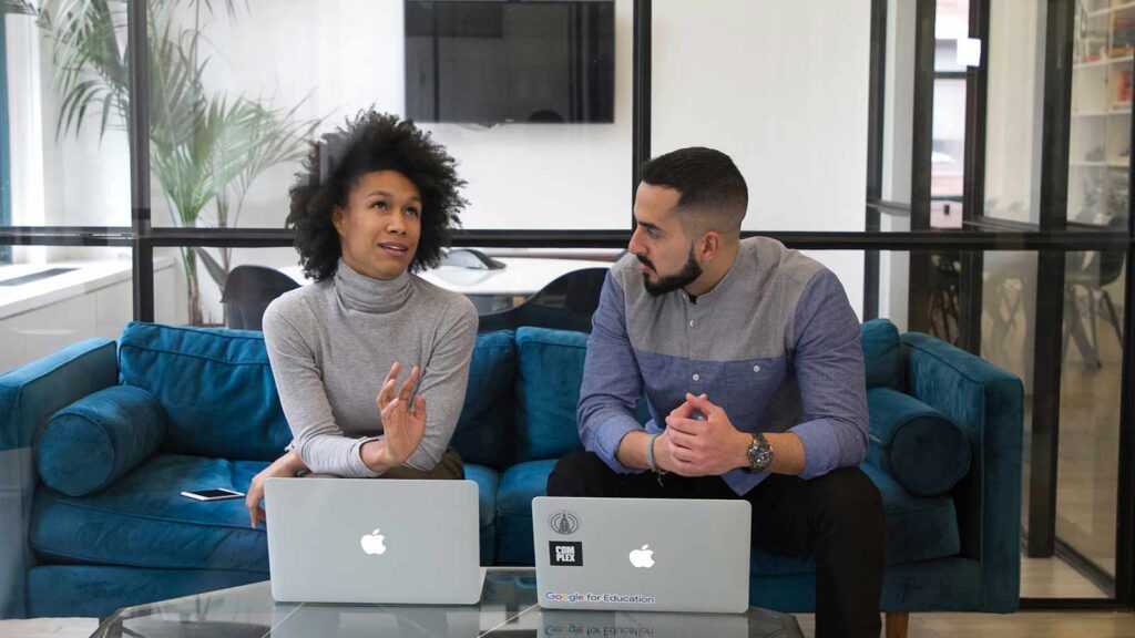 a man and woman sitting on a couch with laptops titlesearcher pre foreclosure homes top local title company abstract company title abstract company find out who owns a property