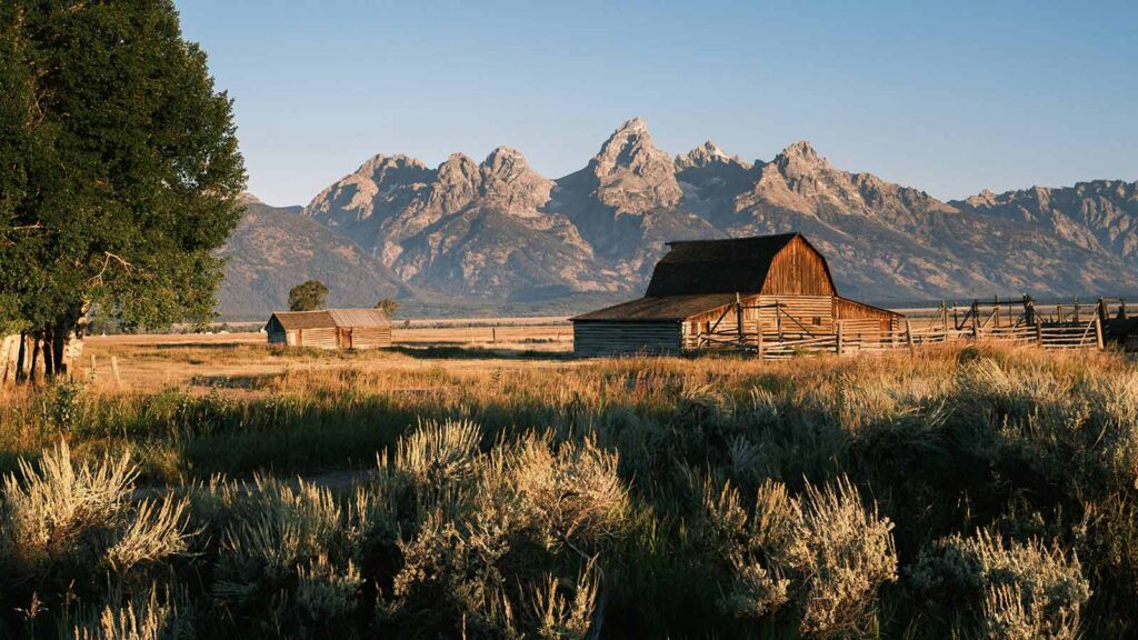 Rustic barn against majestic mountains. AI title search in Wyoming